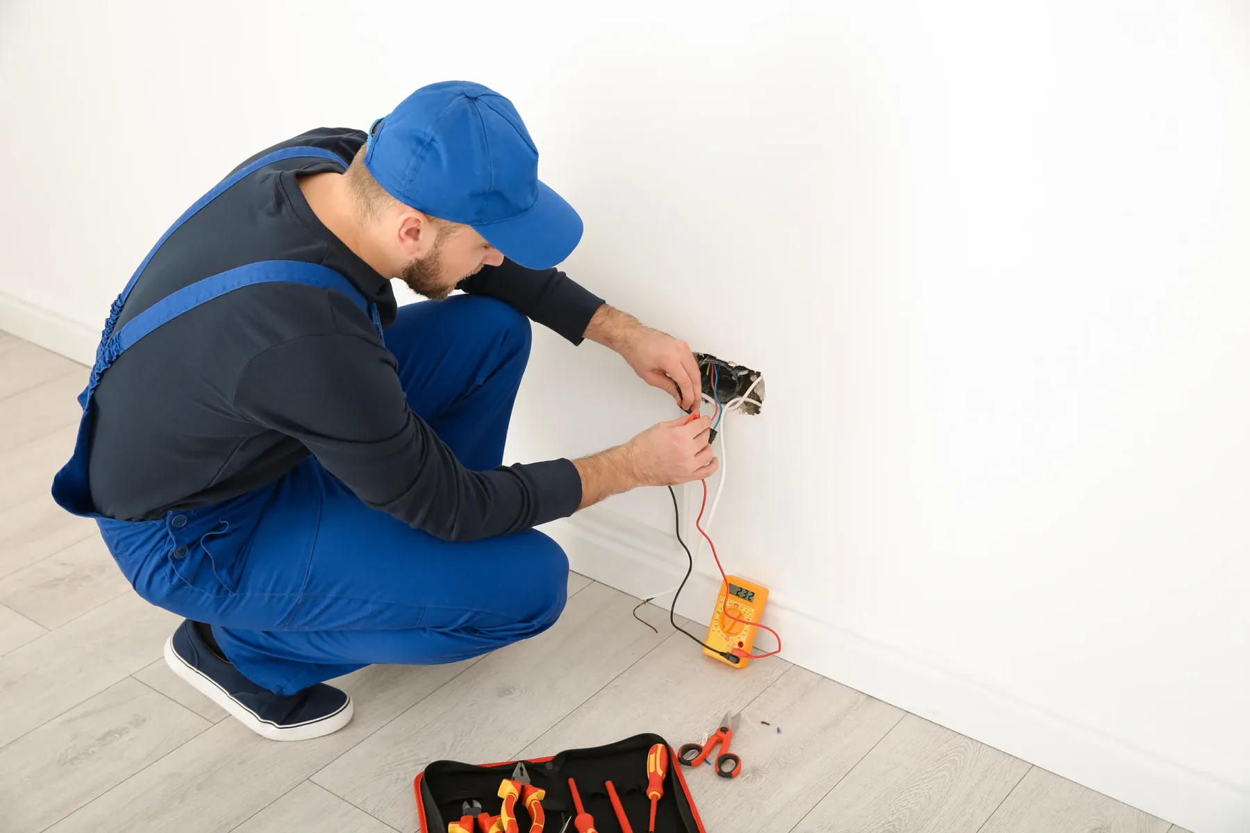 Electrician testing a household wall socket.